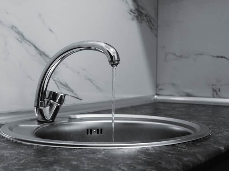 Polished chrome kitchen faucet gleaming after a clean