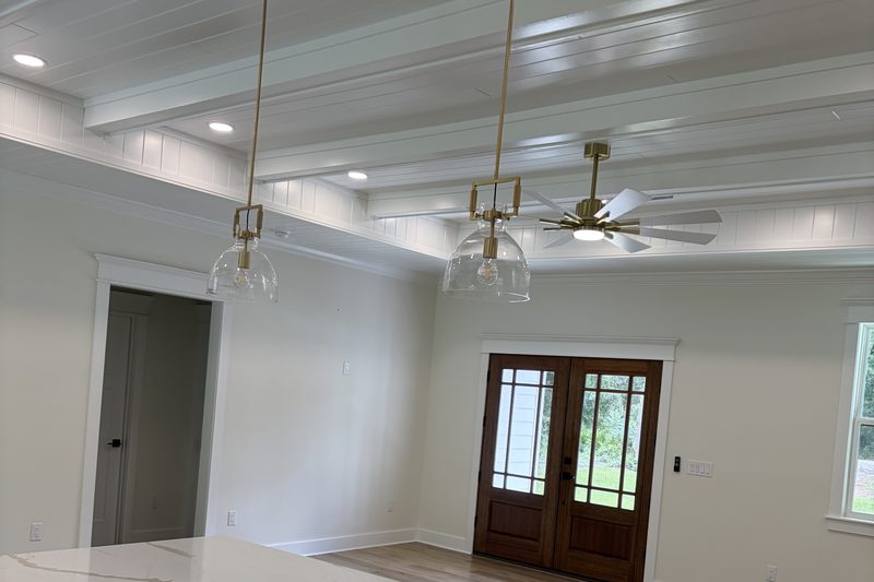 New-build great room with a coffered ceiling and glazed front doors after post-construction cleanup