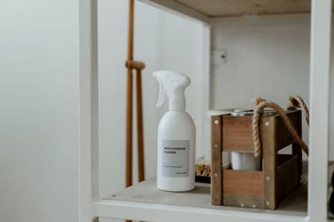 Multi-purpose cleaner and supplies arranged on a shelf